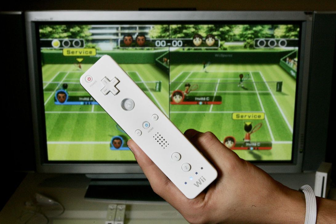 Nintendo Wii controller and Wii tennis game on a TV screen