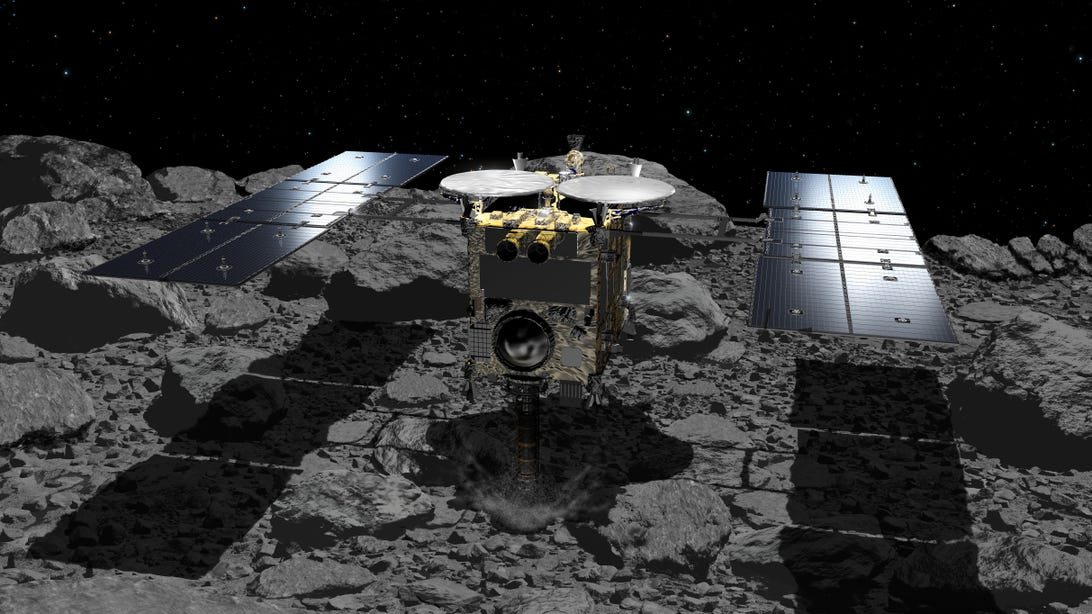 A spacecraft with two large solar arrays touches down on a rocky gray surface