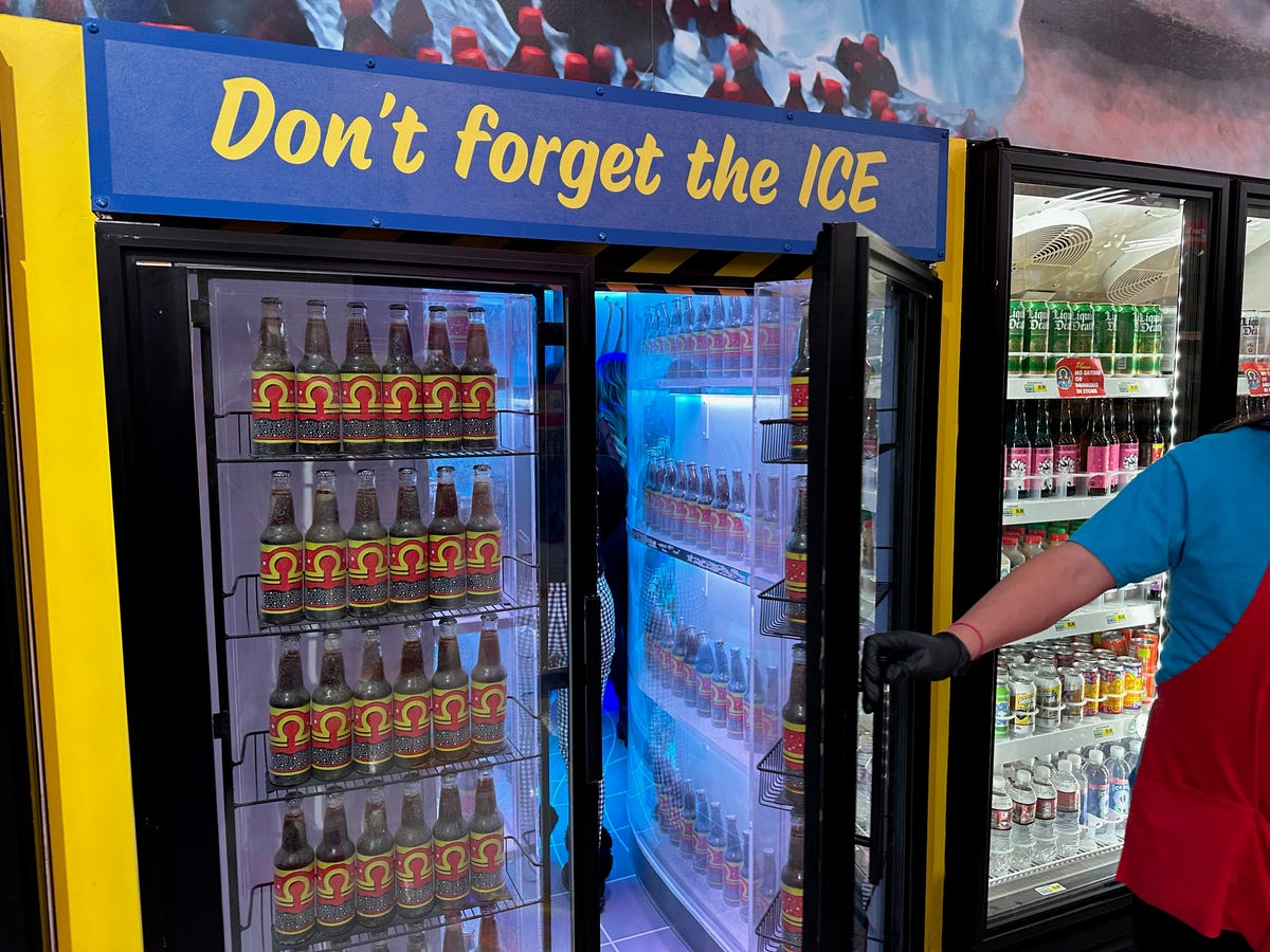 A art installation beverage refrigerator in a convenience store that leads into a special hallway