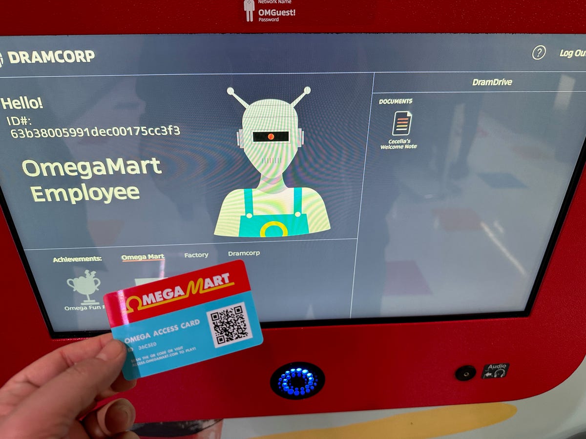 Holding an Omega Mart card in front of a kiosk screen