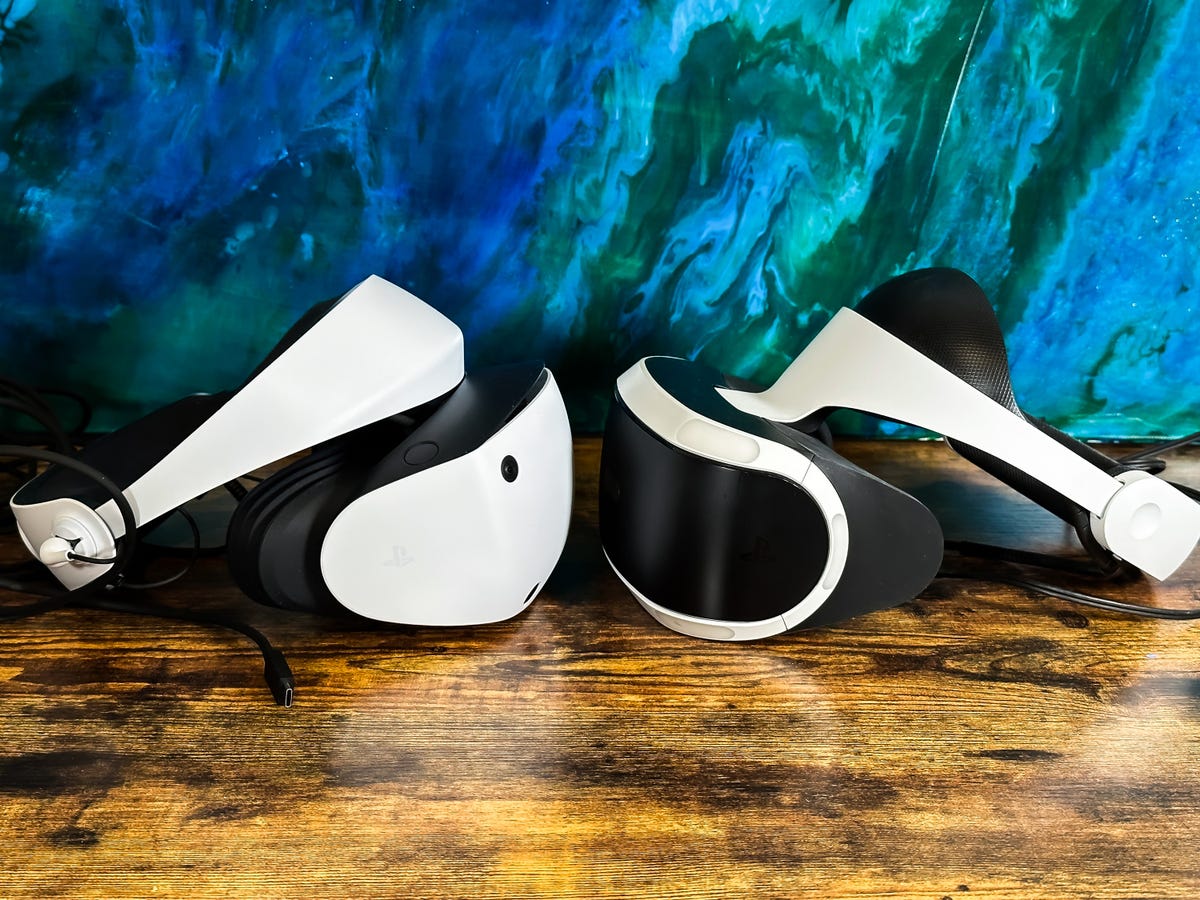 Two VR headsets facing each other on a wooden table